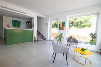 a living room with a green counter and chairs at Hotel Arte Mare in San Vito lo Capo