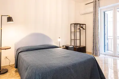 a bedroom with a bed with a blue blanket on it at Il gabbiano a Ballarò in Palermo