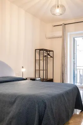 a white bedroom with a bed and a window at Il gabbiano a Ballarò in Palermo