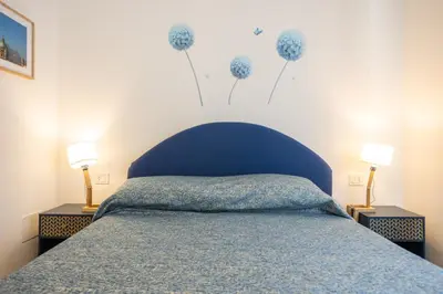 a bedroom with a blue bed with flowers on the wall at Il gabbiano a Ballarò in Palermo