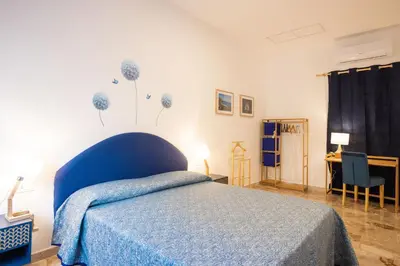 a bedroom with a blue bed with a blue blanket at Il gabbiano a Ballarò in Palermo
