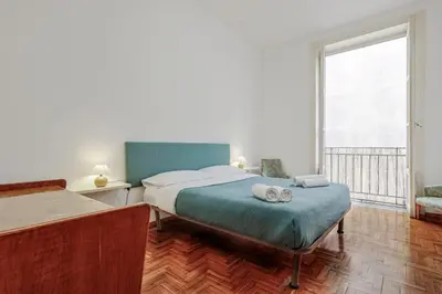 a bedroom with two beds and a large window at GuestHost - Teatro Massimo Lovely Flat with Balconies in Palermo