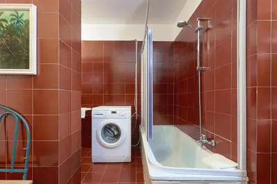 a bathroom with a washing machine and a shower at GuestHost - Teatro Massimo Lovely Flat with Balconies in Palermo