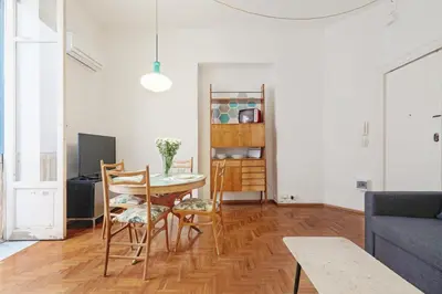 a living room with a table and chairs and a couch at GuestHost - Teatro Massimo Lovely Flat with Balconies in Palermo