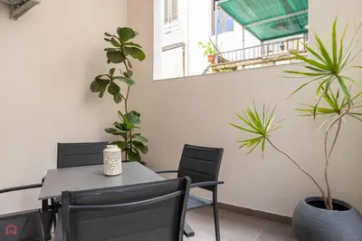 a dining room with a table and chairs and plants at MolteVolte Rooms in Palermo