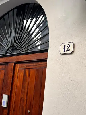 a sign above a wooden door with the number at LB Home in Termini Imerese