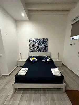 a bedroom with a bed with pillows on it at LB Home in Termini Imerese