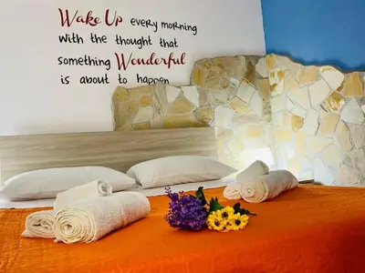 a bedroom with towels and flowers on a bed at Casa Niní in Campofelice di Roccella
