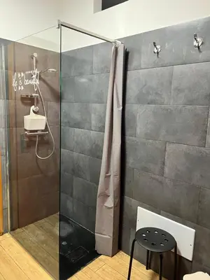 a shower with a glass door in a bathroom at Casa Niní in Campofelice di Roccella