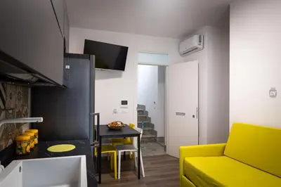 a living room with a green couch and a table at Aura di Grecale in San Vito lo Capo