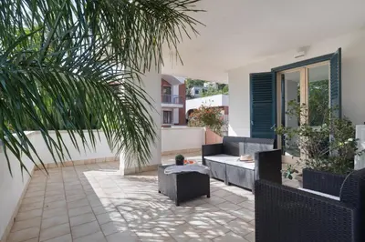 a patio with furniture and a palm tree at Hector's House by DomuSicily in Palermo