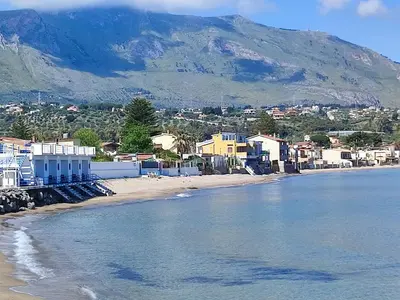 a view of a beach with houses and a mountain at Allegroitalia Torre Artale Palermo in Trabia