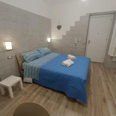 a bedroom with a blue bed with towels on it at Casa alla Stazione in Palermo