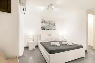 a white bedroom with a bed with two towels on it at Casa Musicò in Palermo