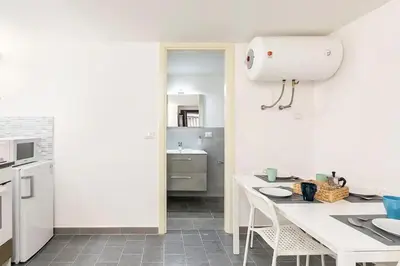 a white kitchen with a table and a sink at Casa Musicò in Palermo