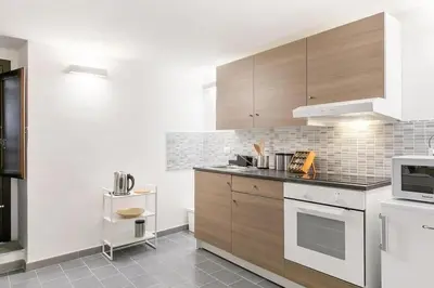 a kitchen with wooden cabinets and a stove top oven at Casa Musicò in Palermo