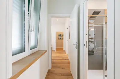 a hallway with white walls and wooden floors at GuestHost - NotHotel Palermo Central Bright Apartment in Palermo
