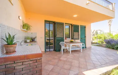 a patio with a table and chairs in a house at Lovely Home In Piane Vecchie,Lascari in Lascari