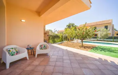 a patio with two chairs and a table and a pool at Lovely Home In Piane Vecchie,Lascari in Lascari