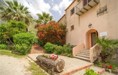 a house with a staircase and flowers in a yard at Amazing Home In San Giuseppe Jato in San Giuseppe Jato