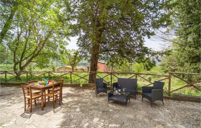 a patio with a table and chairs and a fence at Rosmarino in San Giuseppe Jato