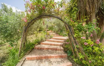an archway with stairs in a garden with flowers at Rosmarino in San Giuseppe Jato