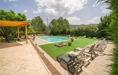 a swimming pool with chairs and a lawn with a pool at Rosmarino in San Giuseppe Jato