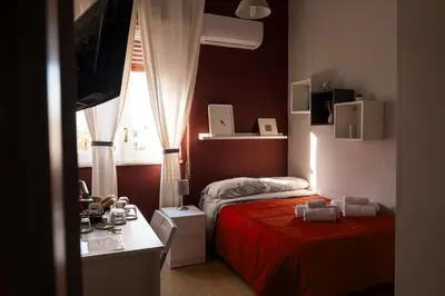 a bedroom with two beds and a desk and a window at S&S in Palermo