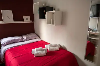 a room with a red bed with towels on it at S&S in Palermo