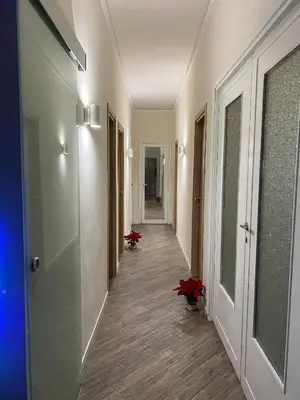 a hallway with white walls and a hallway with red flowers at S&S in Palermo