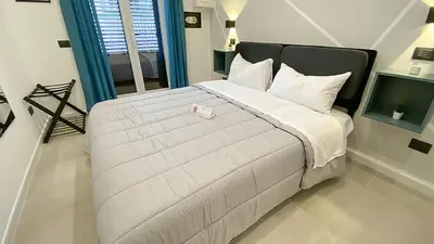 a bedroom with a large white bed with a stuffed animal on it at Palermo Central in Palermo
