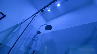 a glass wall with a lamp and blue lights at Palermo Central in Palermo