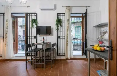 a kitchen with a table and a desk with a television at DaMé in Palermo