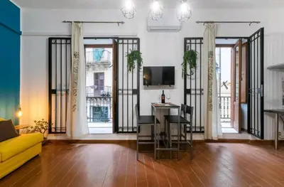 a living room with a yellow couch and some windows at DaMé in Palermo