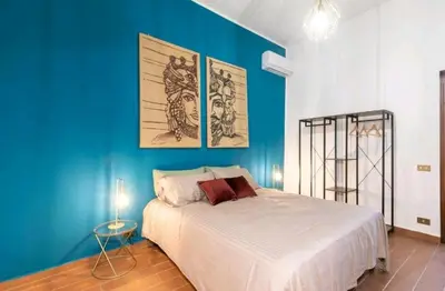 a bedroom with a blue wall with a bed at DaMé in Palermo