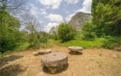 a group of stone benches sitting on a field at Salvia in San Giuseppe Jato