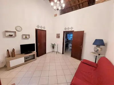 a living room with a red couch and a tv at CASA di ARTHUR in Palermo
