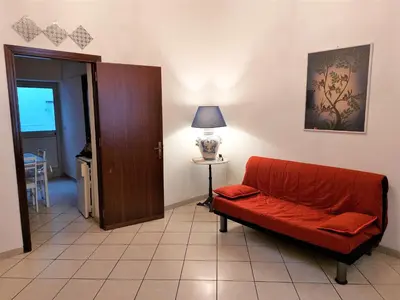 a living room with a red couch and a lamp at CASA di ARTHUR in Palermo