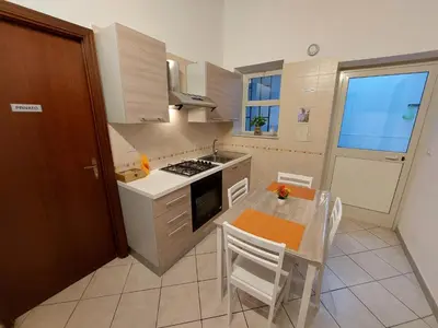 a kitchen with a table and a stove top oven at CASA di ARTHUR in Palermo