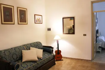 a living room with a couch and a guitar at Sicilia Nica - appartamento privato a Cinisi (PA) in Cinisi