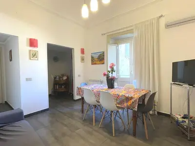 a dining room with a table with chairs and a television at Residenza Lincoln in Palermo