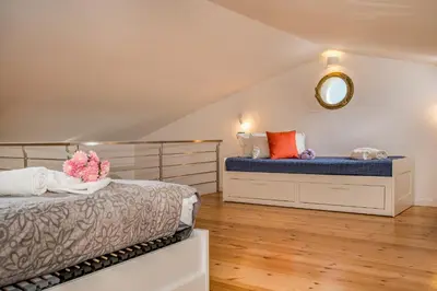 a attic bedroom with two beds and a mirror at Villa Holidays in Torre Bennistra in Scopello