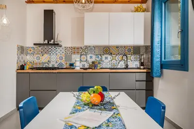 a kitchen with a table with a bowl of fruit on it at Villa Holidays in Torre Bennistra in Scopello