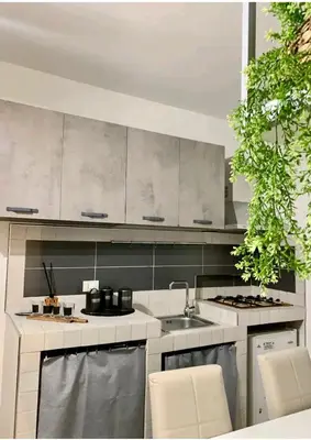 a kitchen with white cabinets and a sink at Montesanto House Palermo in Palermo