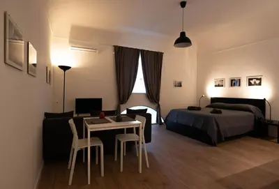 a bedroom with a bed and a table and chairs at Monolocale Ramondetti Fileti in Palermo