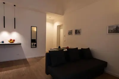 a living room with a black couch and a counter at Monolocale Ramondetti Fileti in Palermo
