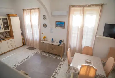 a kitchen with a table and a dining room at Ciuri Ciuri in Isola delle Femmine