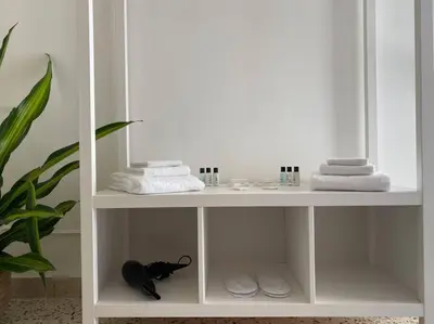 a white bathroom shelf with towels and towels at Orethus Apartment - Exclusive Palermo Center in Palermo