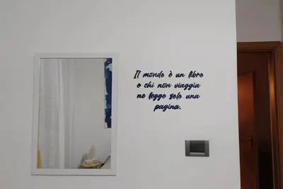 a mirror with a quote on the wall next to a door at Coral sea B2 in San Vito lo Capo