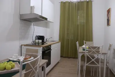 a kitchen with a sink and a table and chairs at GREENHOME in Palermo